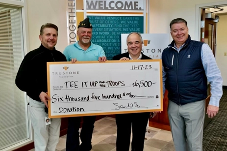 TruStone Employees holding a large donation check for $6,500 for Tee It Up For the Troops