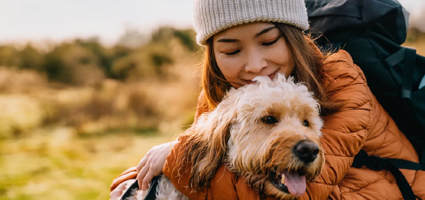 woman holding dog and smiling.