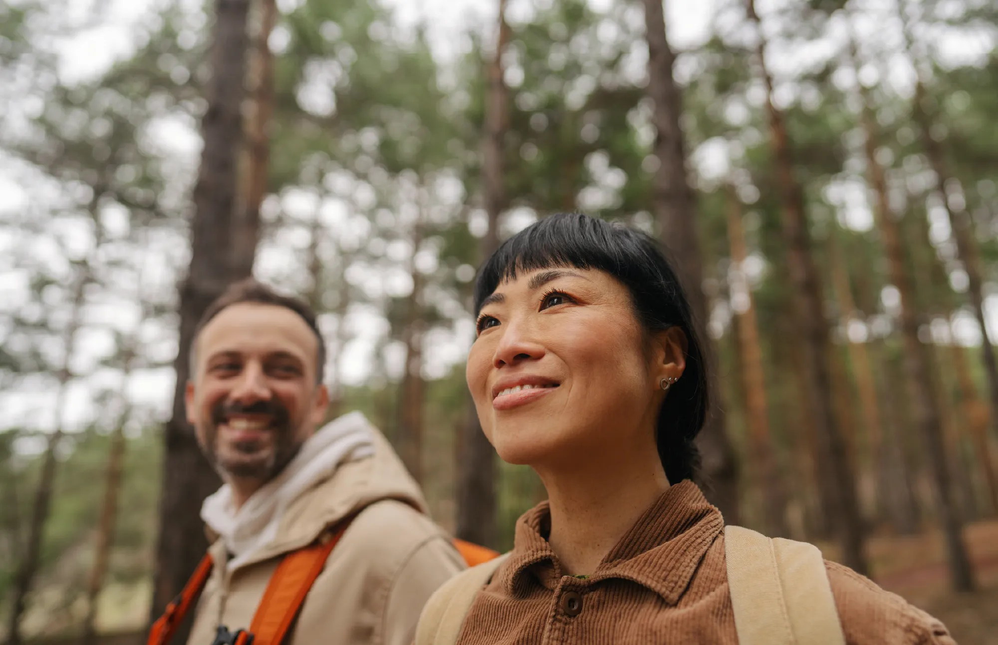 two people walking in the woods.