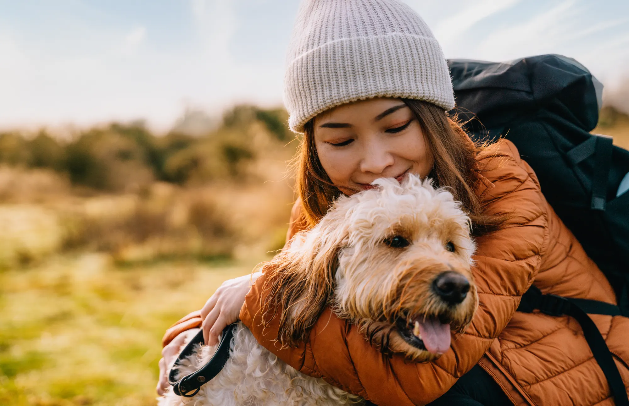 woman holding dog and smiling.