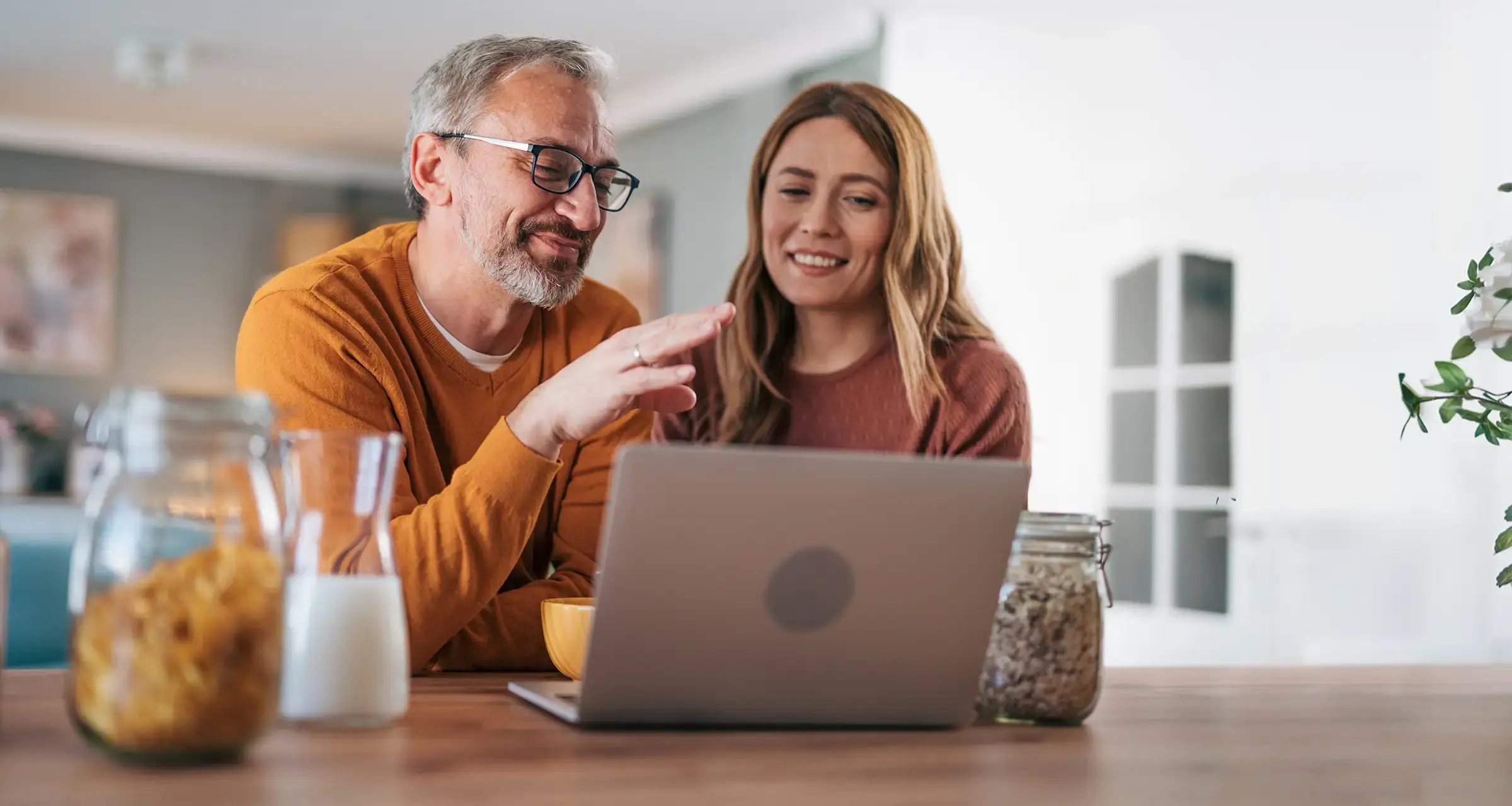 Man and woman looking at a laptop smiling