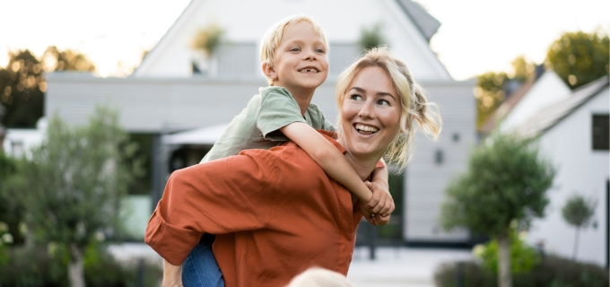 Woman giving a child a piggyback ride